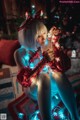 A woman sitting on the floor in front of a Christmas tree.