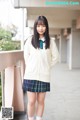 A young woman in a school uniform posing for a picture.