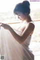 A woman in a towel is looking out a window.