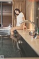 A woman sitting on a counter in a bathroom.