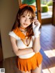 A woman in an orange and white outfit posing for a picture.